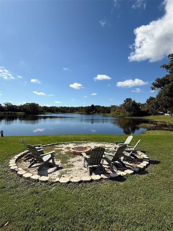 22710 Watersedge Boulevard, Unit 73 Land O' Lakes, FL 34639 - Photo 26 of 39 a view of a lake with lawn chairs and an umbrella