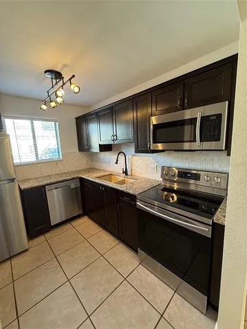 a kitchen with a sink and steel appliances