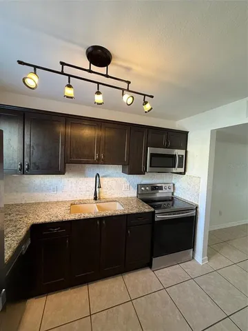 a kitchen with stainless steel appliances granite countertop a sink and a stove