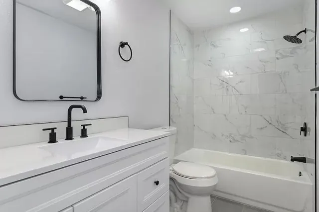 a bathroom with a sink a toilet and shower