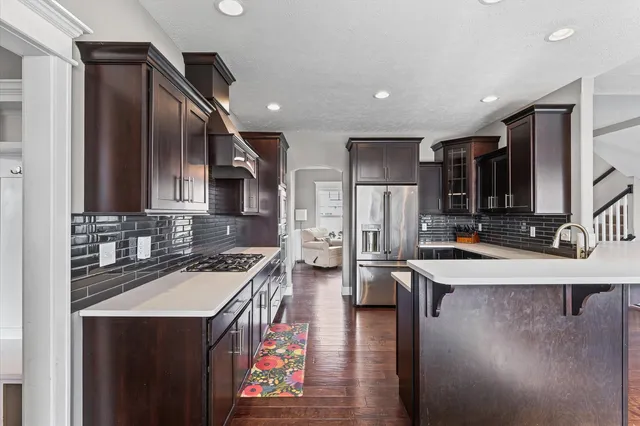 a kitchen with stainless steel appliances granite countertop a sink a stove and a refrigerator