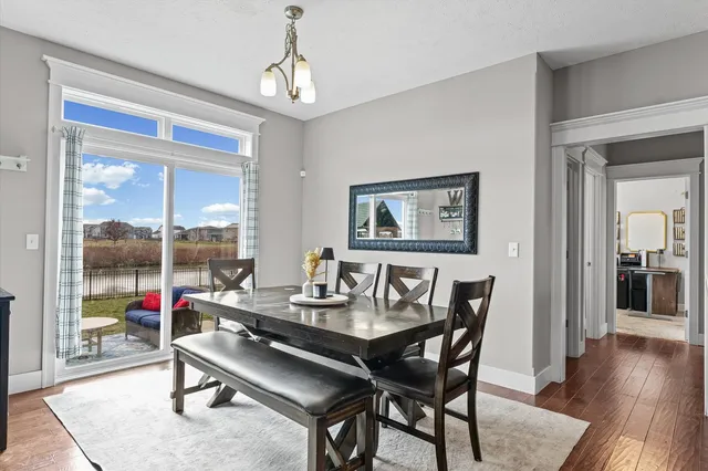 a dining room with wooden floor and a chandelier