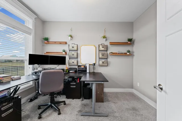 a view of a workspace with furniture and a window