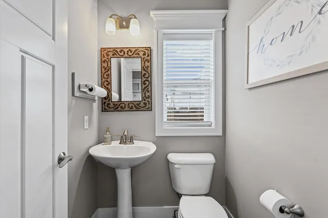 a bathroom with a toilet sink and mirror