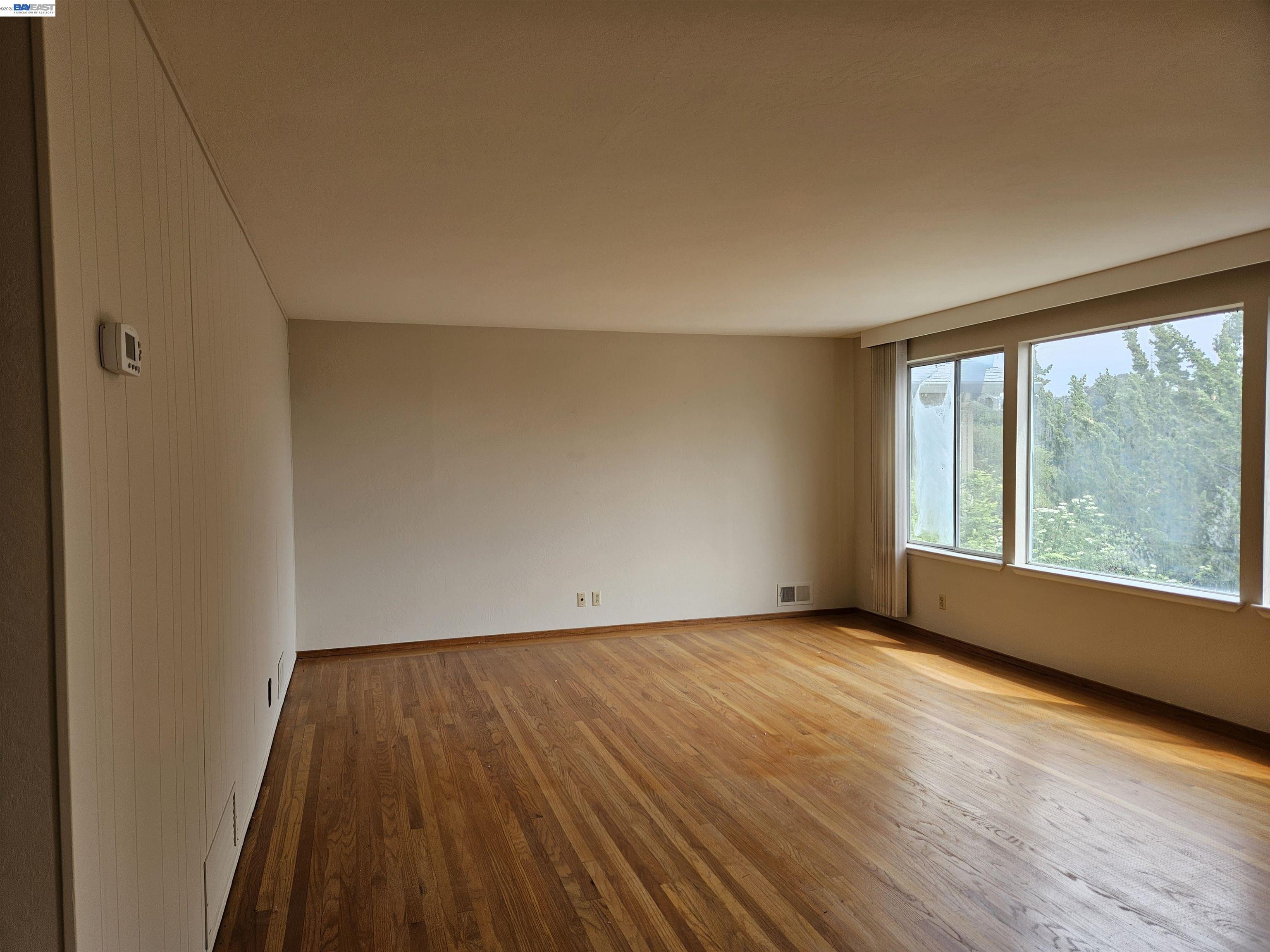 18758 Crane Avenue Castro Valley, CA 94546 - Photo 2 of 13 a view of an empty room with wooden floor and a window