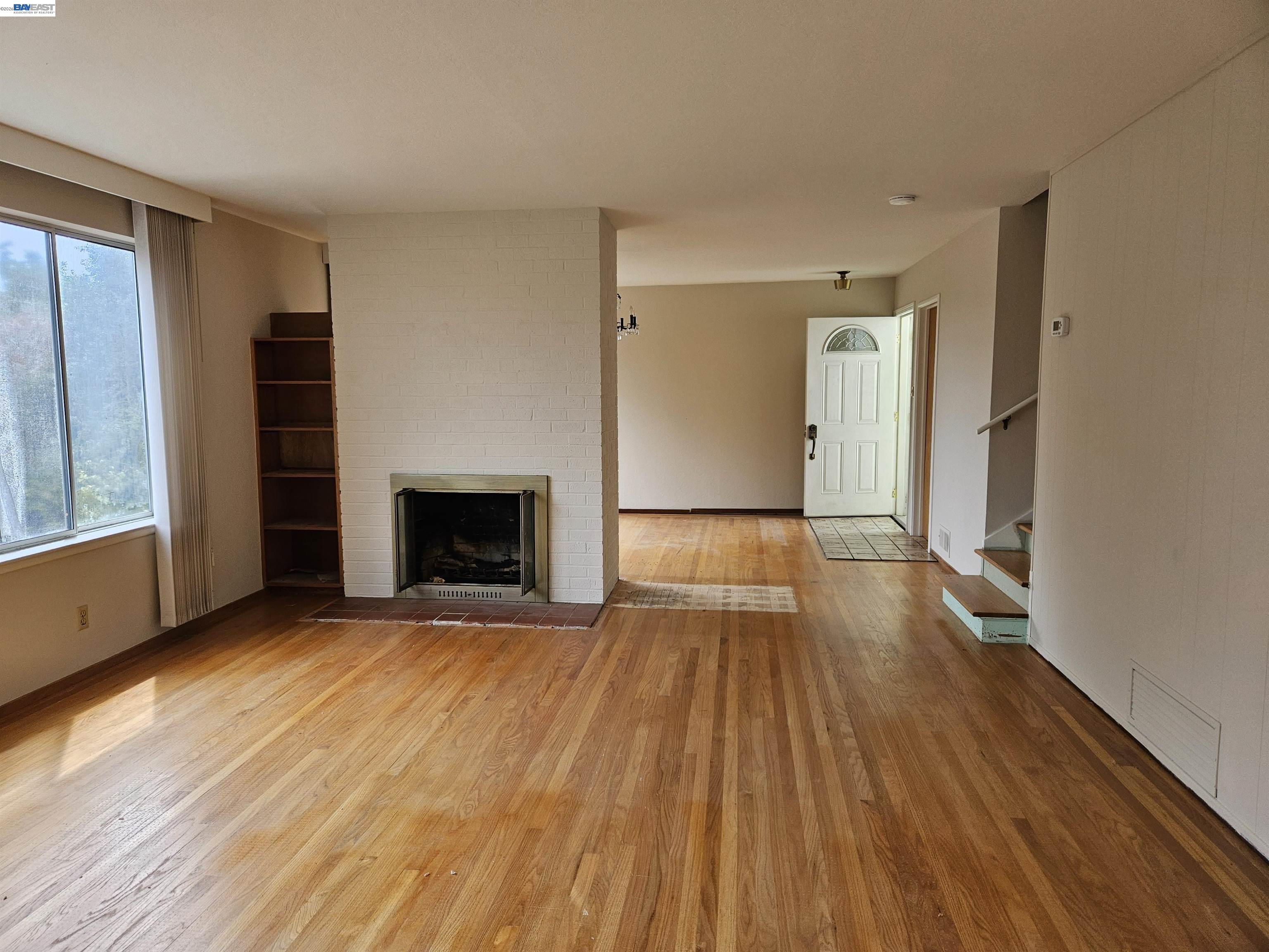 18758 Crane Avenue Castro Valley, CA 94546 - Photo 3 of 13 a view of an empty room with wooden floor fireplace and a window