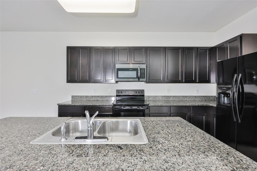 8969 Indigo Trail Loop Riverview, FL 33578 - Photo 18 of 41 a kitchen with a refrigerator and a sink