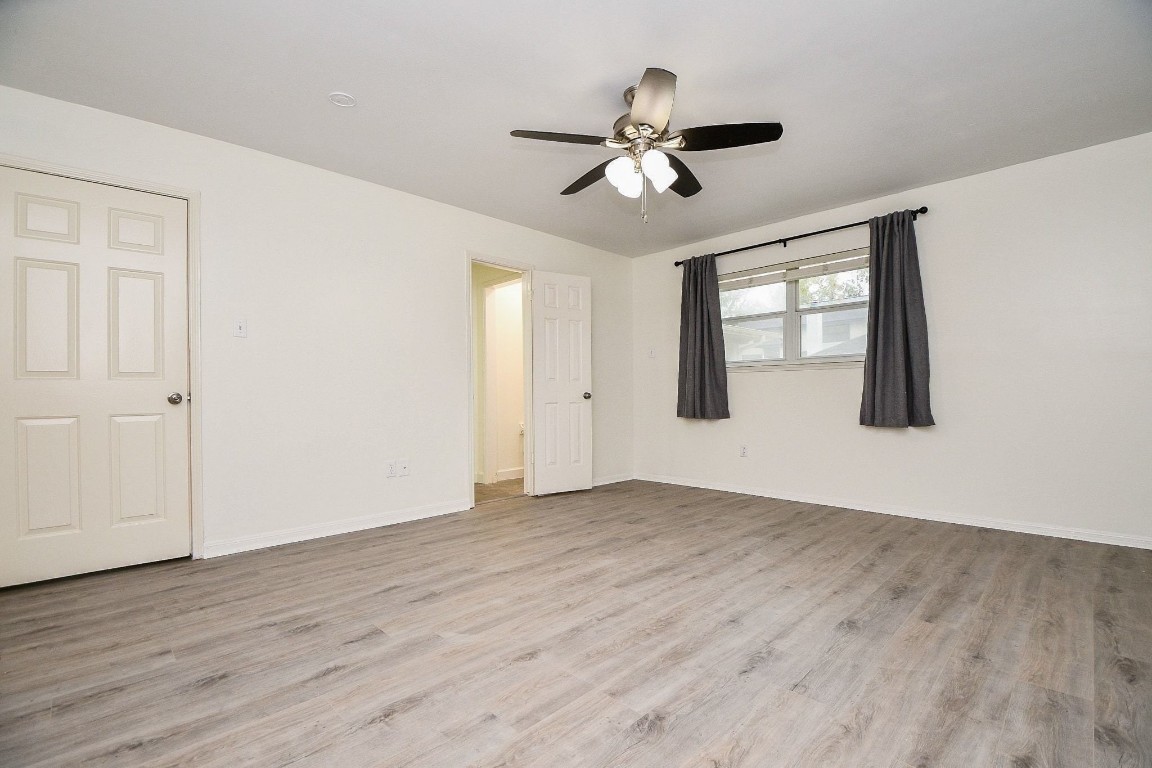 14011 Wickersham Lane Houston, TX 77077 - Photo 21 of 38 a view of an empty room with wooden floor and a window