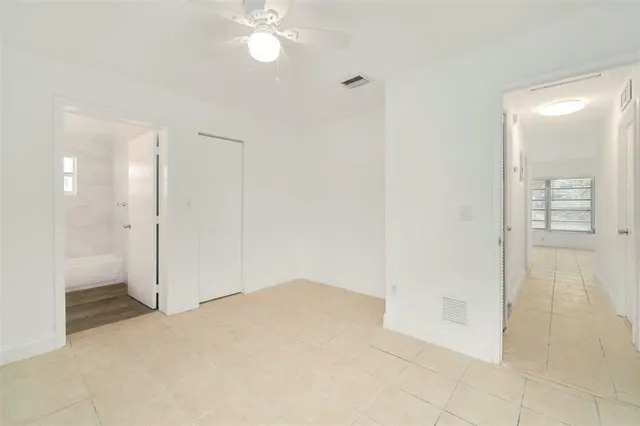 an empty room with fan and entrance