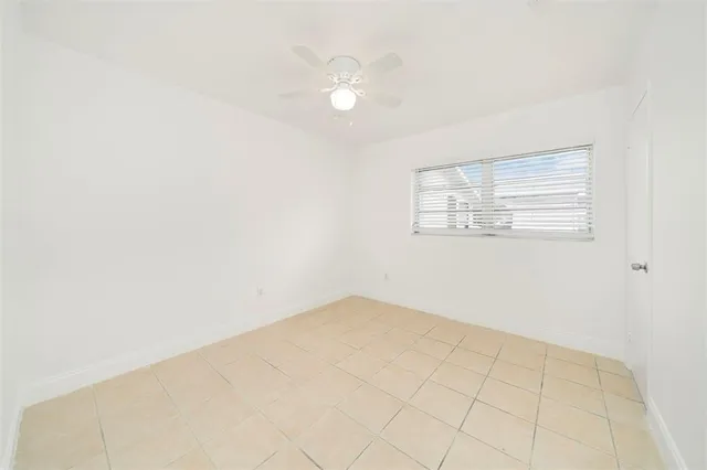 an empty room with a white walls and a ceiling fan