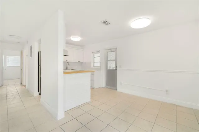a view of a kitchen with refrigerator and more cabinets