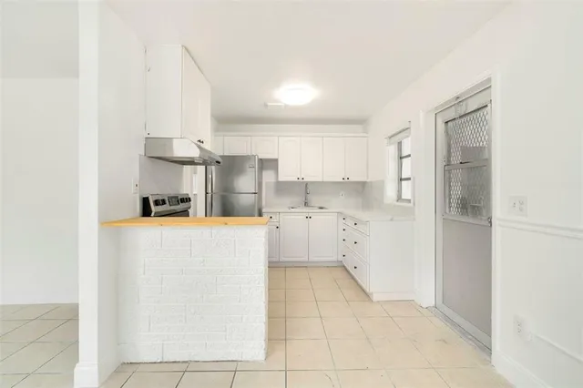 a kitchen with cabinets and a refrigerator