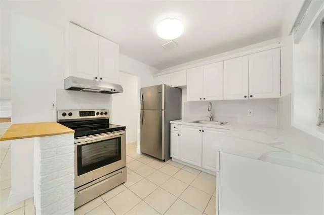 a kitchen with stainless steel appliances a stove refrigerator sink and cabinets