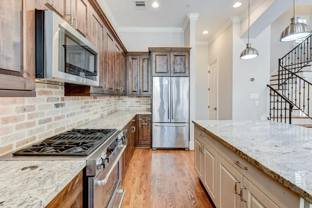 a kitchen with stainless steel appliances granite countertop a stove a refrigerator and a microwave
