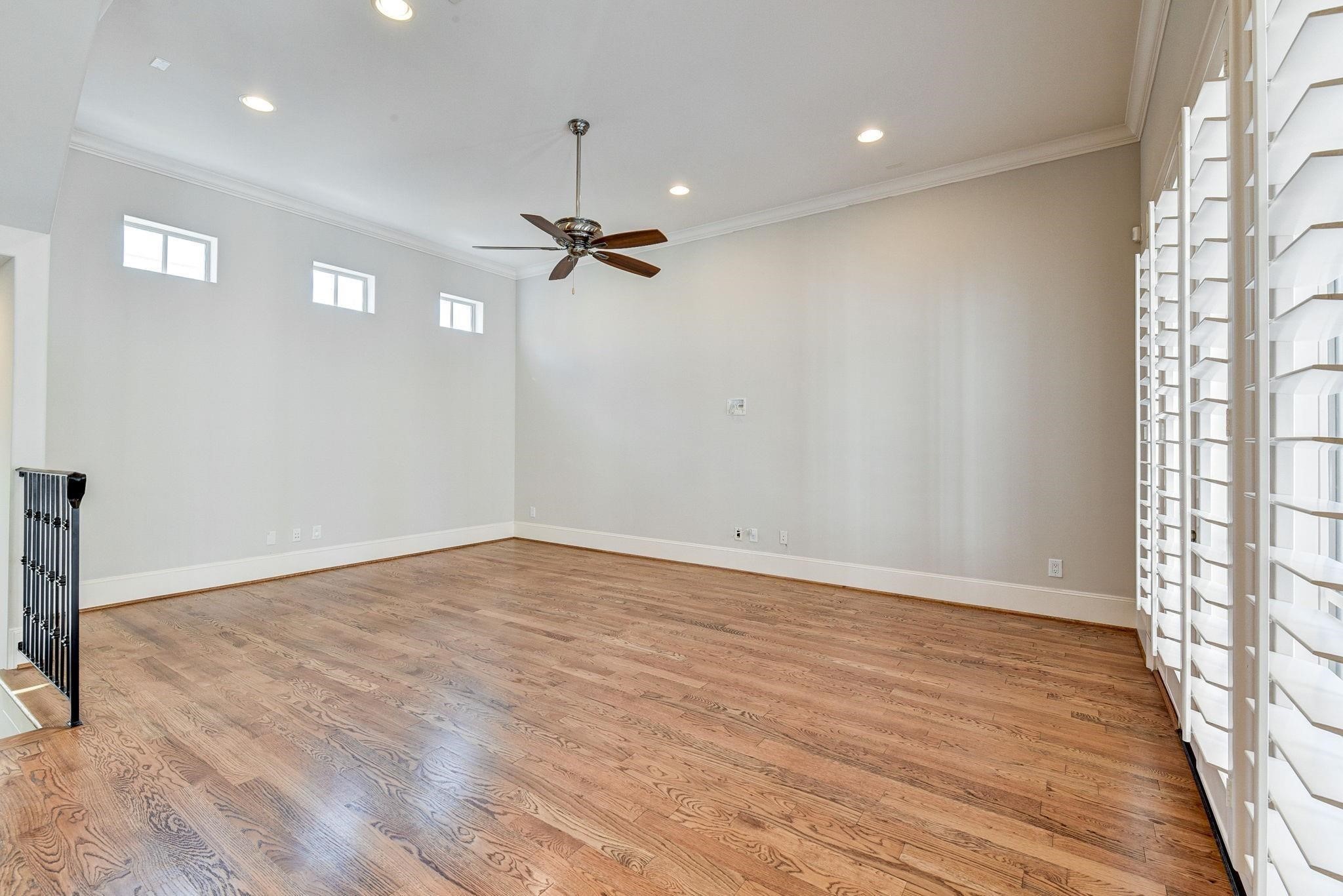 4506 Jackson Street Houston, TX 77004 - Photo 24 of 29 an empty room with wooden floor fan and windows