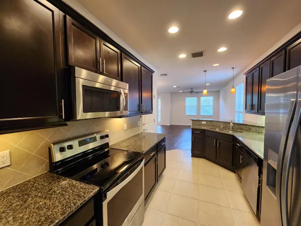 a kitchen with stainless steel appliances granite countertop a stove and a microwave