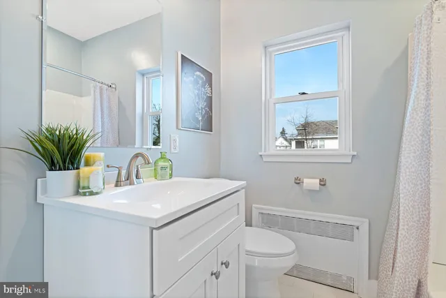 a bathroom with a sink a toilet and a mirror