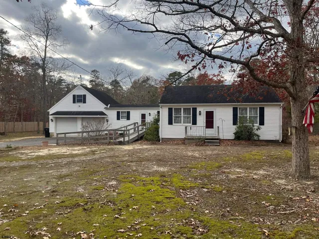a front view of a house with a garden and yard