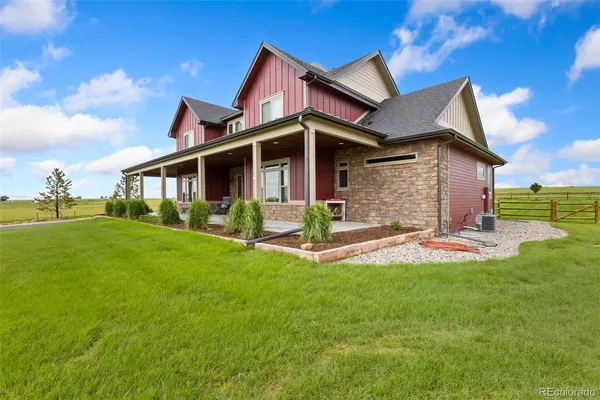 a view of a house with a yard and porch