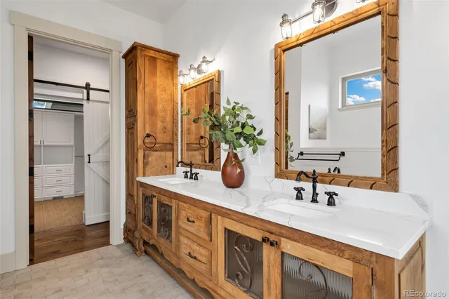 a spacious en suite bathroom with double vanity and a mirror