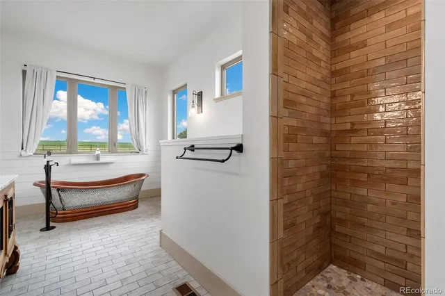 a white bath tub sitting in a bathroom next to a window
