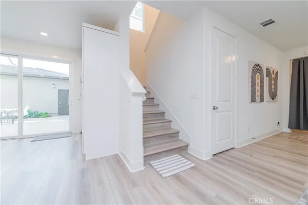 a view of a hallway with wooden floor and entryway