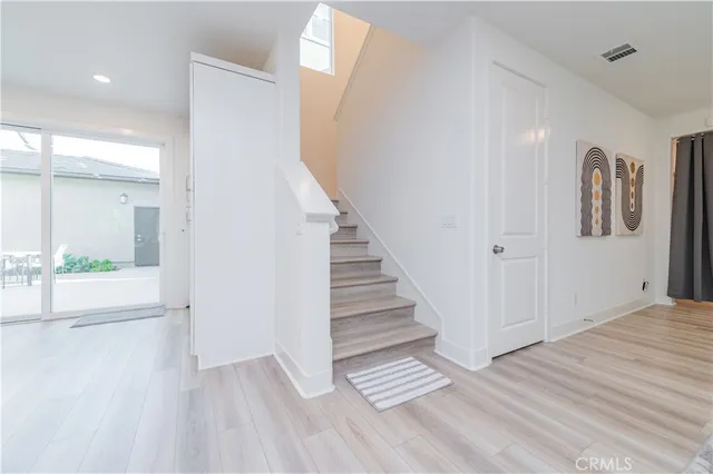 a view of a hallway with wooden floor and entryway