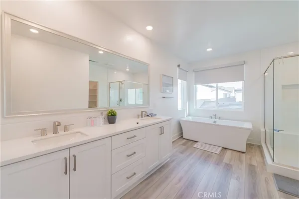 a bathroom with a double vanity sink a mirror and a bathtub