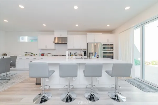 a kitchen with a dining table chairs and view of living room