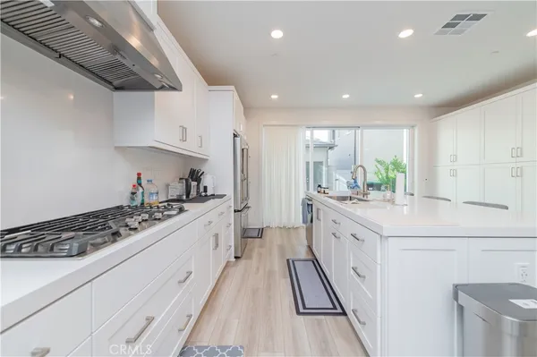 a large kitchen with stainless steel appliances sink stove and cabinets