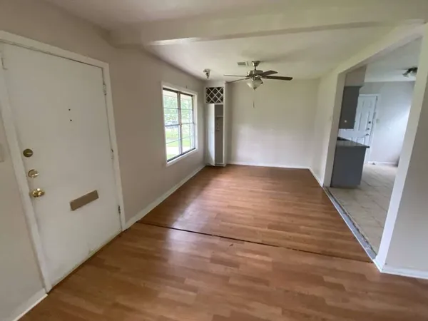 wooden floor in an empty room with a window
