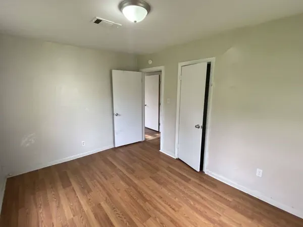 an empty room with wooden floor and entrance
