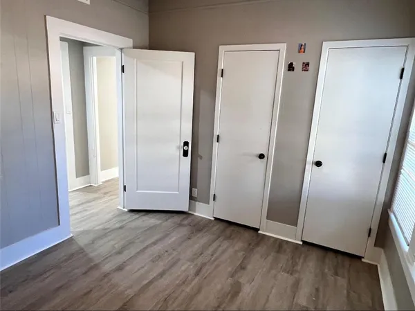 a view of empty room with wooden floor and window
