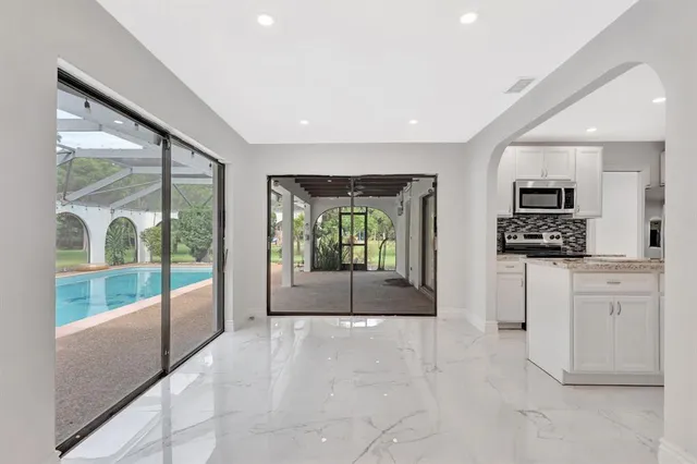 a view of kitchen with stainless steel appliances refrigerator oven and cabinets