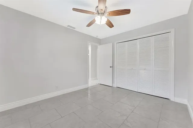 an empty room with a ceiling fan and a window