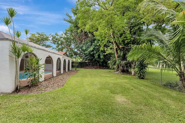 an aerial view of residential houses with outdoor space and trees