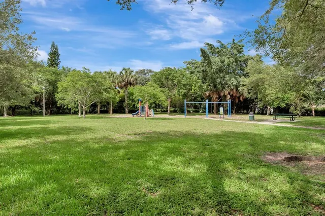 an aerial view of residential houses with outdoor space and trees
