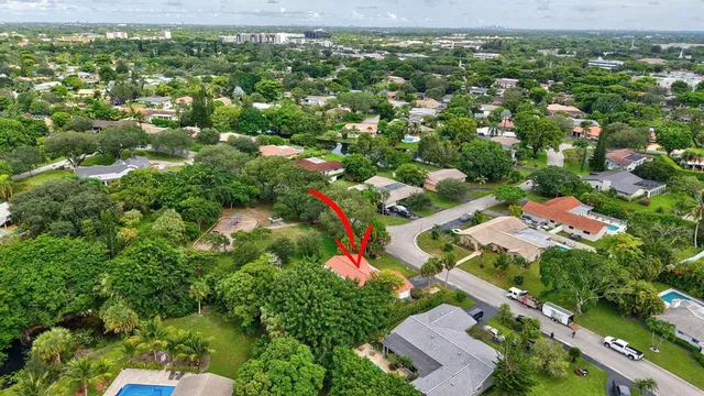 an aerial view of a house with a yard and a large tree