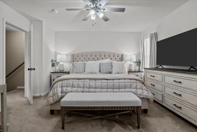 a bedroom with a bed and a flat tv screen on dresser