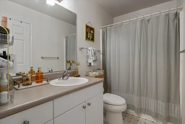 a bathroom with a sink a toilet and shower curtain