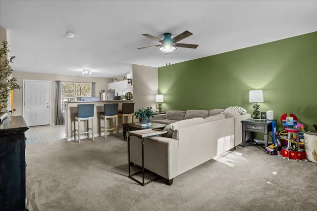 a living room with furniture and a dining table with kitchen view