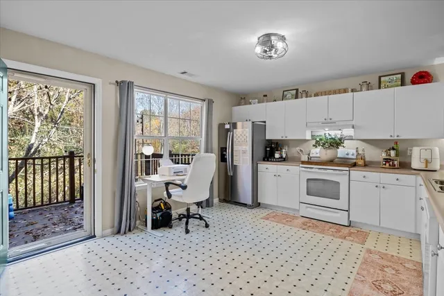 a kitchen with stainless steel appliances kitchen island granite countertop a refrigerator and cabinets
