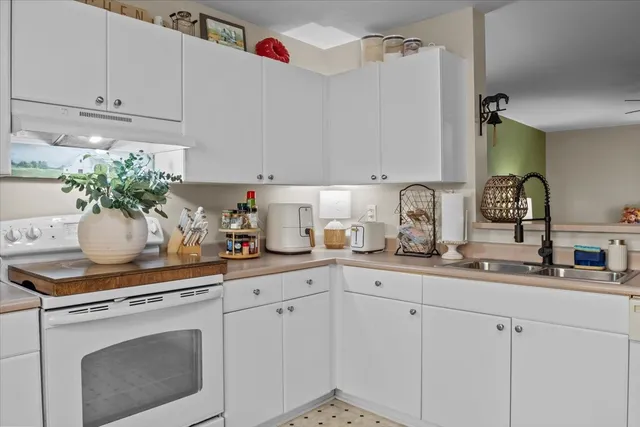 a kitchen with white cabinets and white appliances