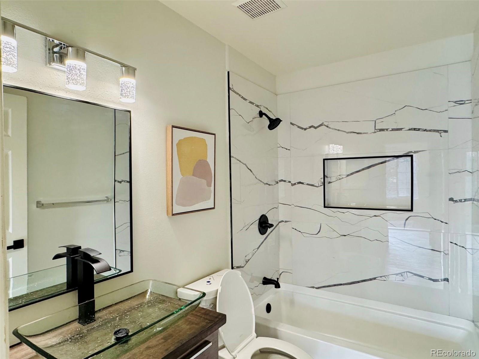 8468 South Thunder Ridge Way, Unit 202 Highlands Ranch, CO 80126 - Photo 11 of 21 a bathroom with a tub sink and toilet