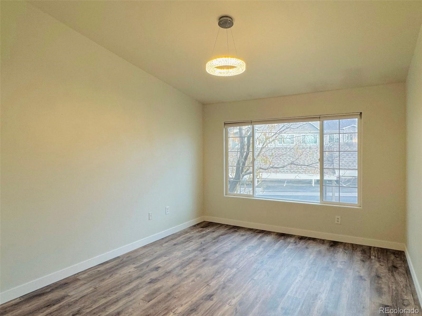 8468 South Thunder Ridge Way, Unit 202 Highlands Ranch, CO 80126 - Photo 13 of 21 an empty room with wooden floor and windows
