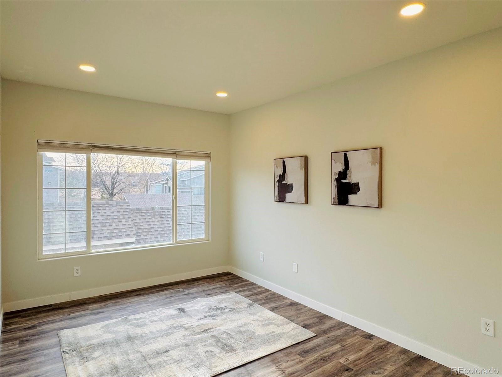 8468 South Thunder Ridge Way, Unit 202 Highlands Ranch, CO 80126 - Photo 15 of 21 a view of an empty room with wooden floor and a window