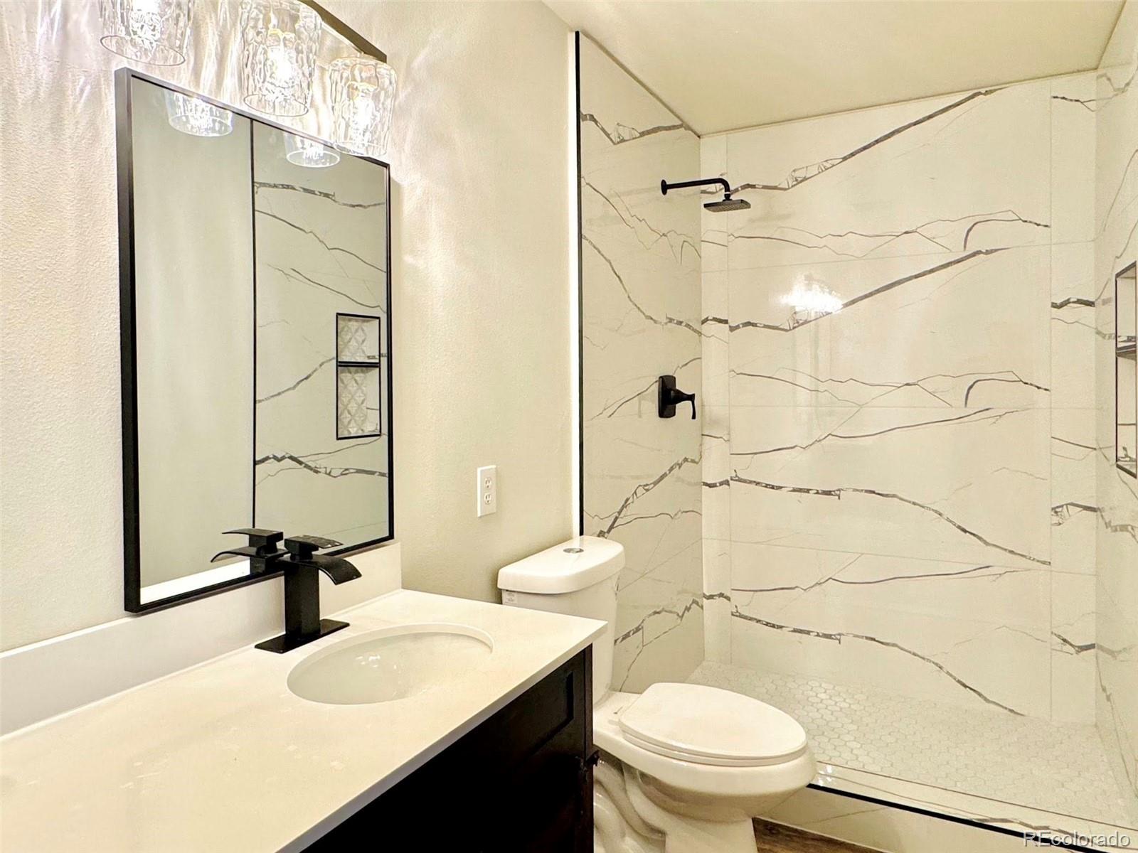 8468 South Thunder Ridge Way, Unit 202 Highlands Ranch, CO 80126 - Photo 5 of 21 a bathroom with a sink toilet and shower