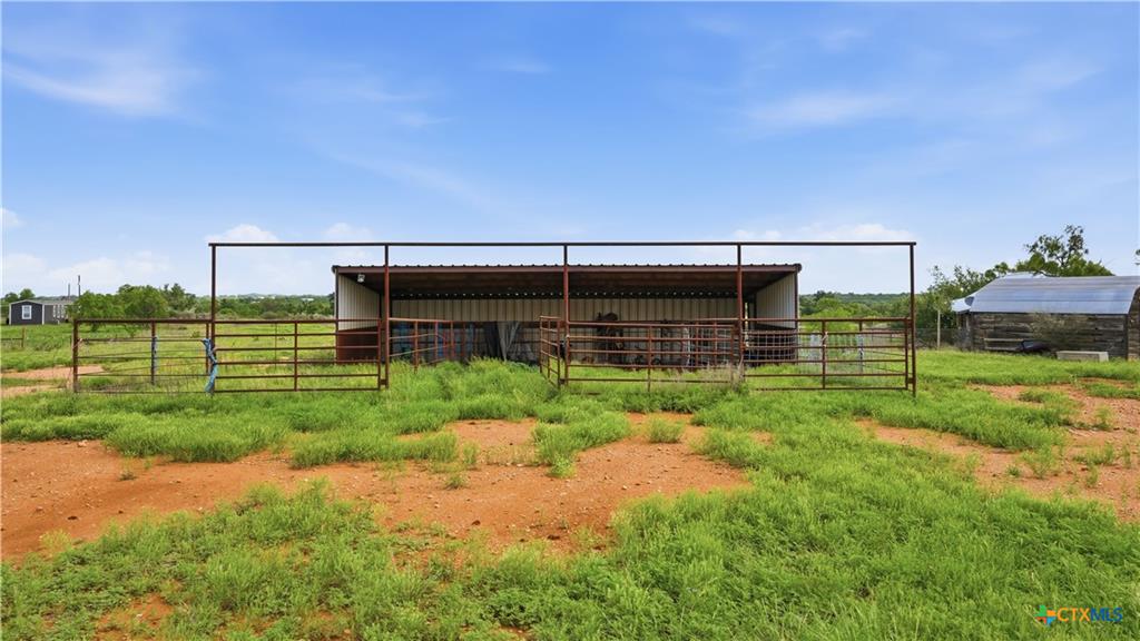 127 Offer Llano, TX 78643 - Photo 29 of 40 Expansive outdoor area featuring a covered metal structure with fenced enclosures and surrounding open land