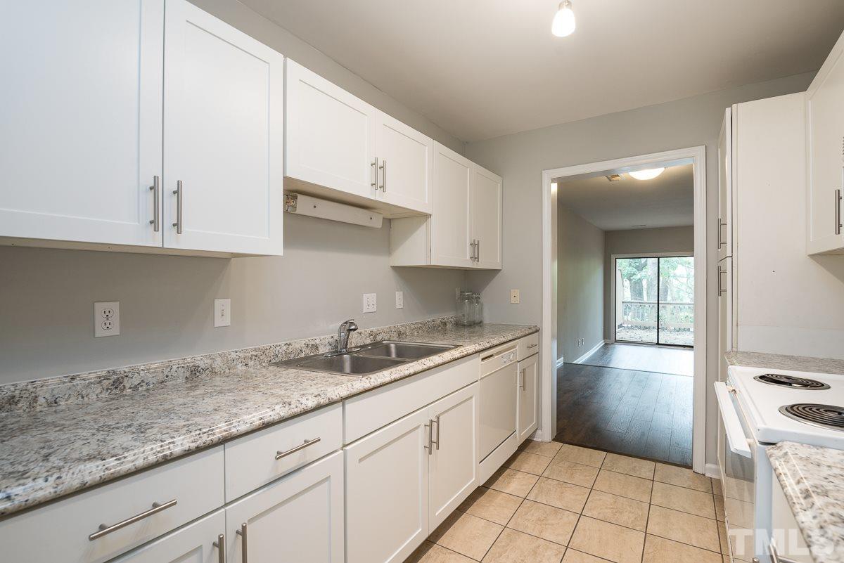 4213 Sunshadow Lane Raleigh, NC 27613 - Photo 11 of 20 a kitchen with granite countertop white cabinets and a sink