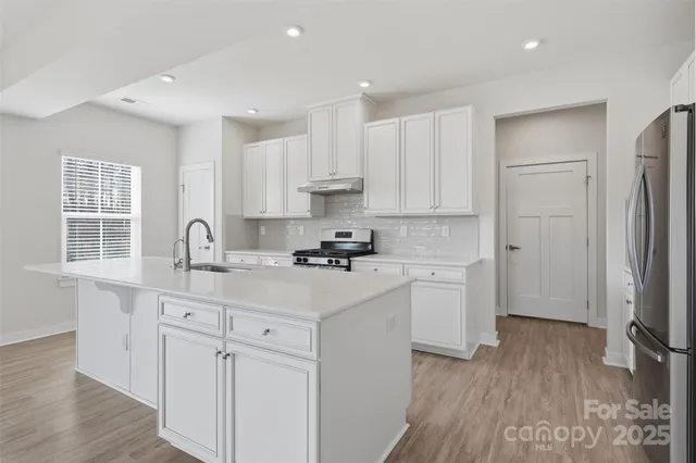 a kitchen with white cabinets and appliances